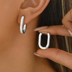 Rectangle hoop earring held between fingers, showing the angular shape