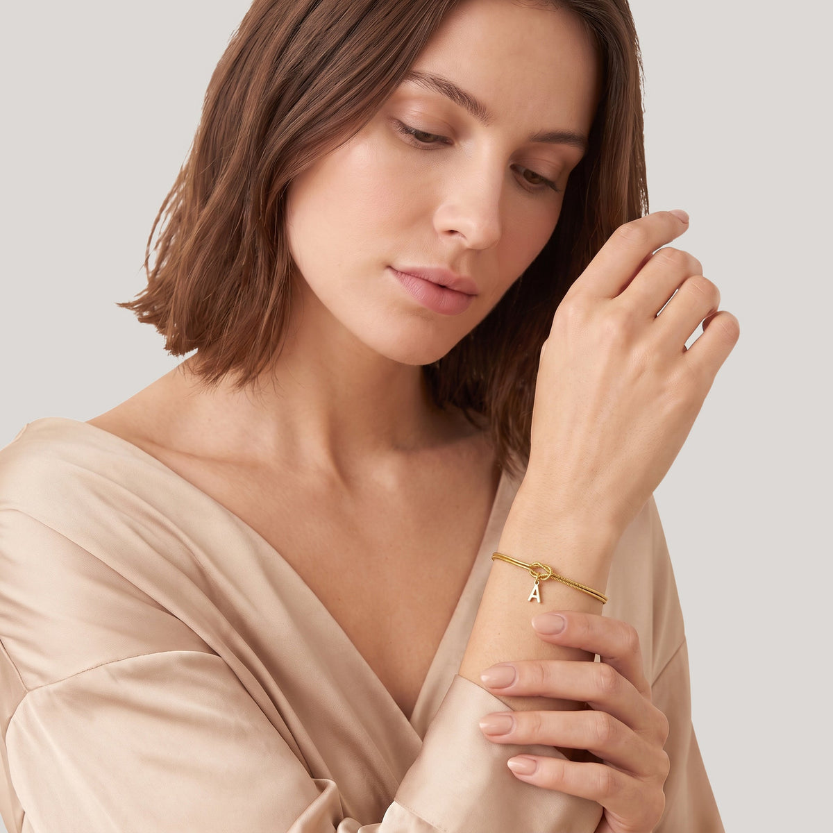 Model wearing the initial knot bracelet in gold