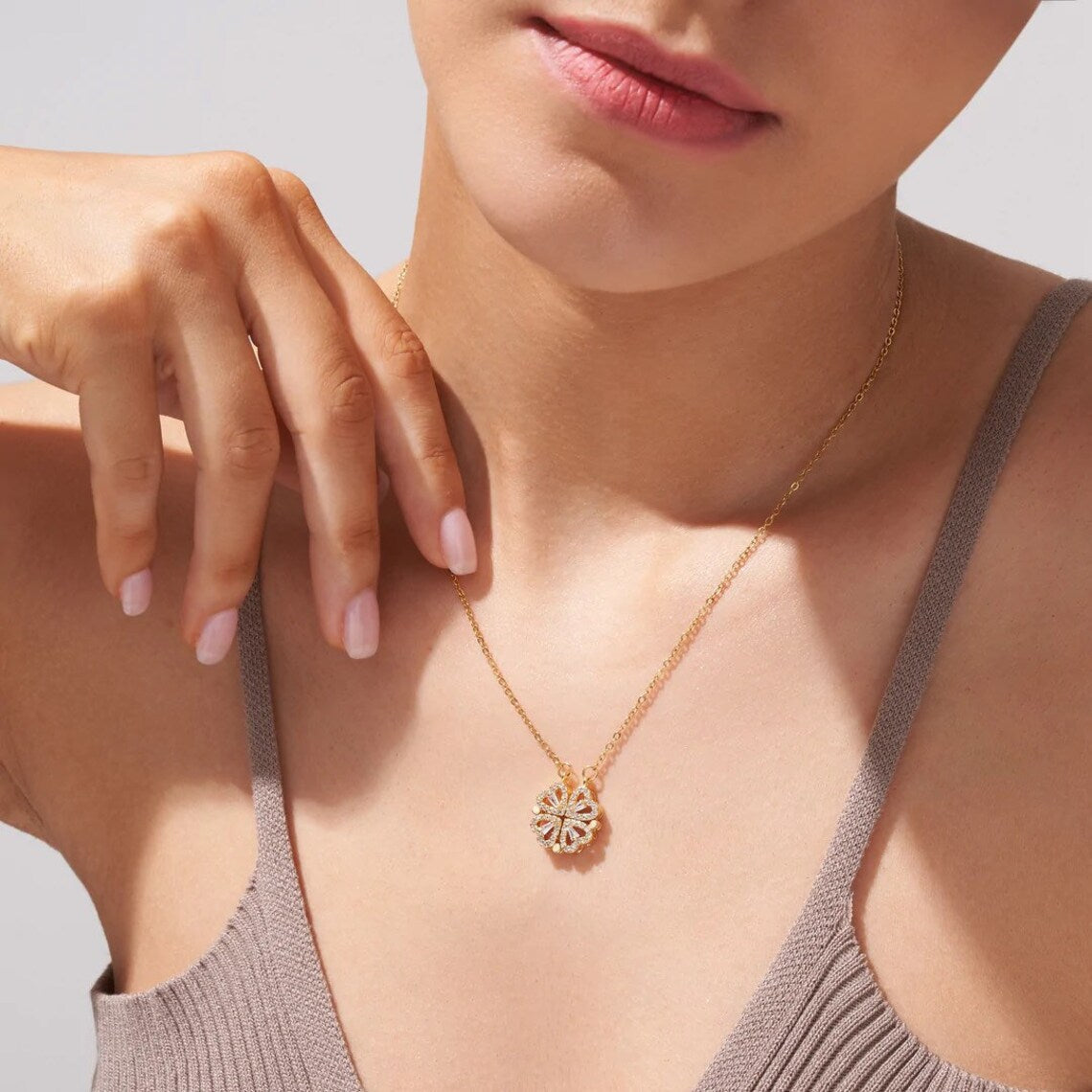 Model wearing the four heart clover necklace in gold