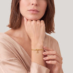 Initial knot bracelet in gold worn on the wrist