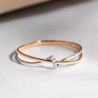Criss-cross ring in rose gold and silver with a single set stone
