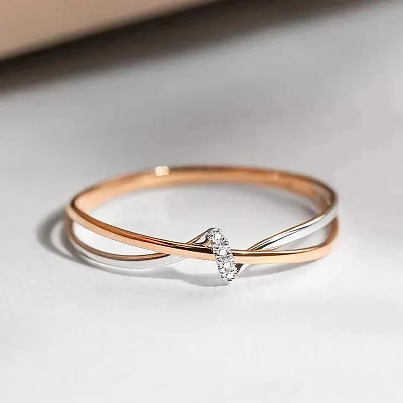 Criss-cross ring in rose gold and silver with a single set stone